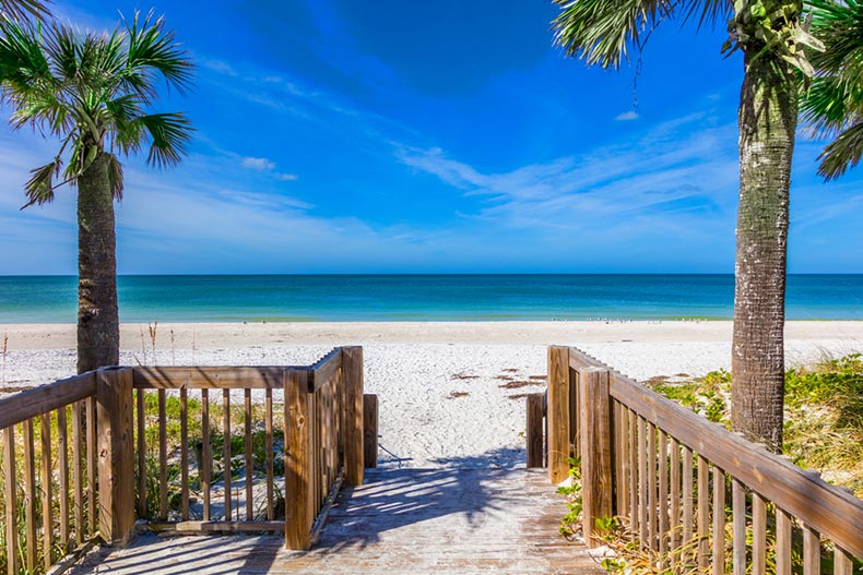 Ocean view from a walkway on a white sand beach.