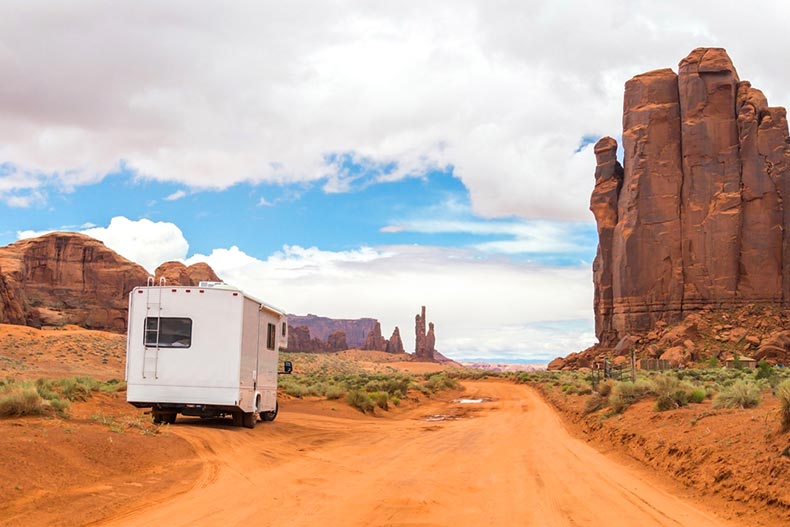 RV parked alongside a red dirt road in Monument Valley National Park.