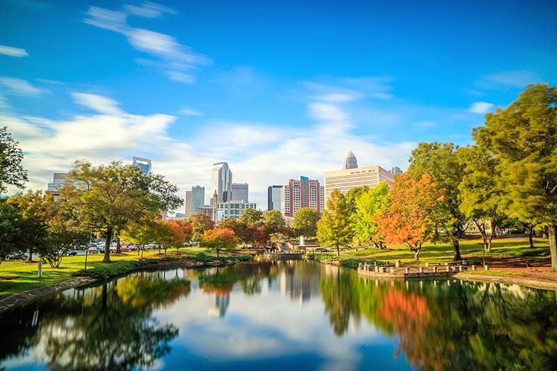 The skyline of Uptown Charlotte and the lake at Marshall Park.