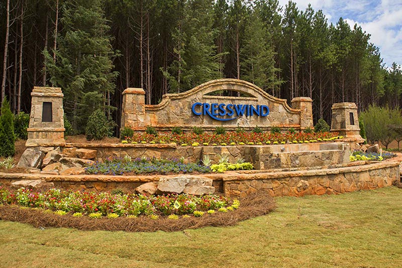 Trees surrounding the welcome sign at the entrance of Cresswind Charlotte, a 55+ community in Charlotte, North Carolina.