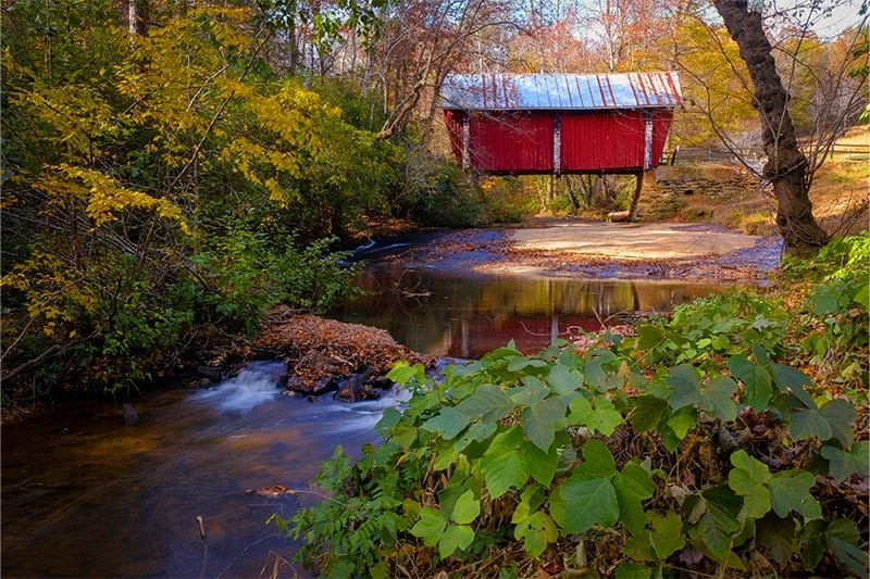Autumn view of old red covered bridge near Greer SC.