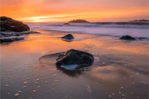 Sunset on sandy and rocky beach in the Bay Area of California.