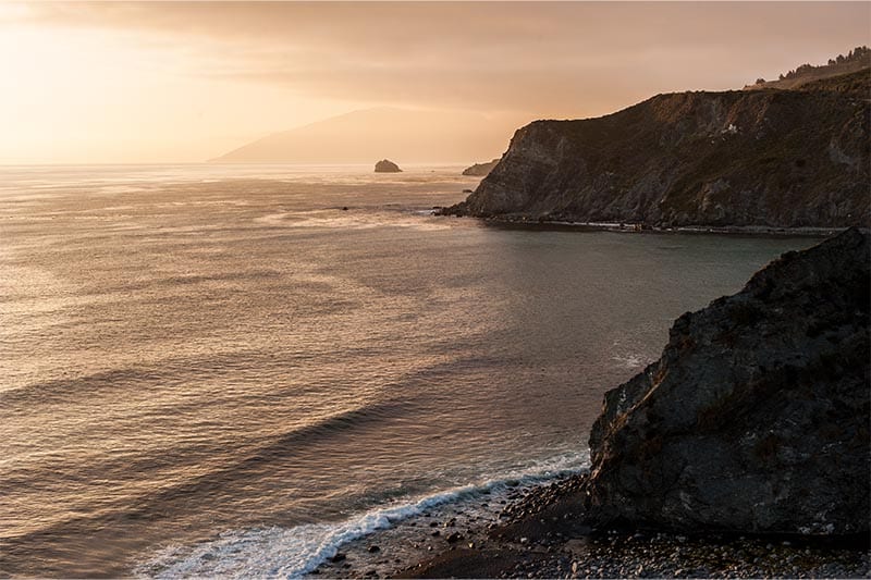 Sunset on Pacific Ocean rocky shores near San Mateo, CA.
