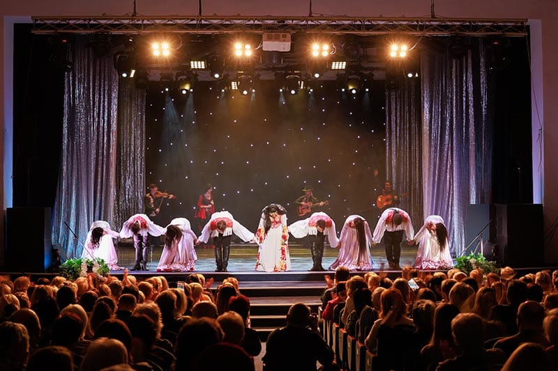 Musicians, singers, and dancers taking a bow on stage at a theater in a 55+ community.