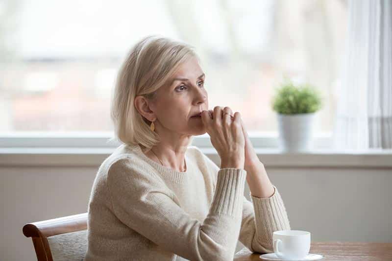 An older adult feels the anxiety of aging and thinks about ways to manage stress.