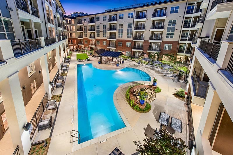 Overview of a pool complex surrounded by condominiums at Overture Buckhead South 55+ retirement living.