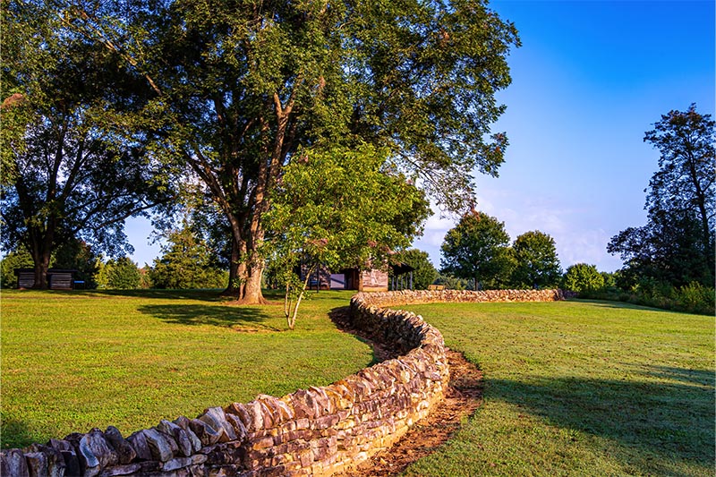 Small rock wall near large oak tree in Joyner Park near Wake Forest, NC.