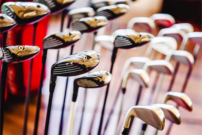 Close up of group of upside down golf clubs.