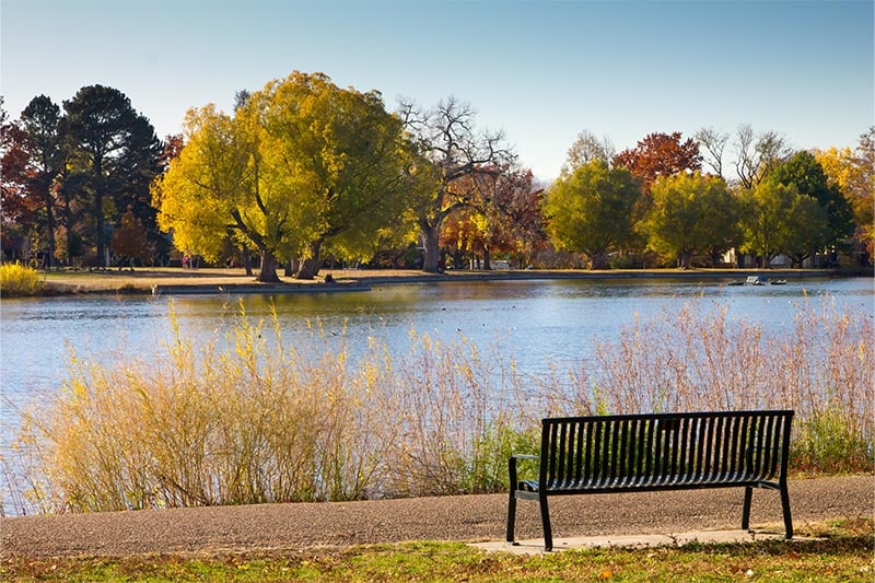 Park bench on lake shore in Autumn.