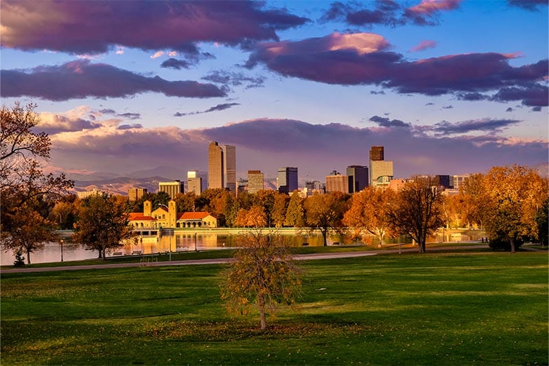 City park with sunset view of Denver skyline.