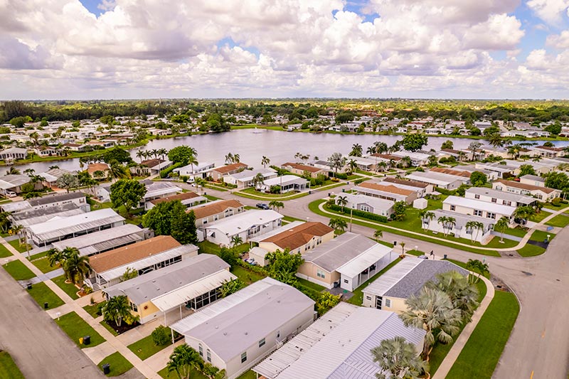 Aerial view of a manufactured home community with a lake in the center.