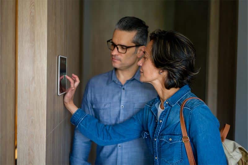 A mature couple sets their alarm as they leave their lock and leave community.