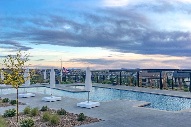 Closed umbrellas beside the outdoor pool at Hilltop at Inspiration in Aurora, Colorado.