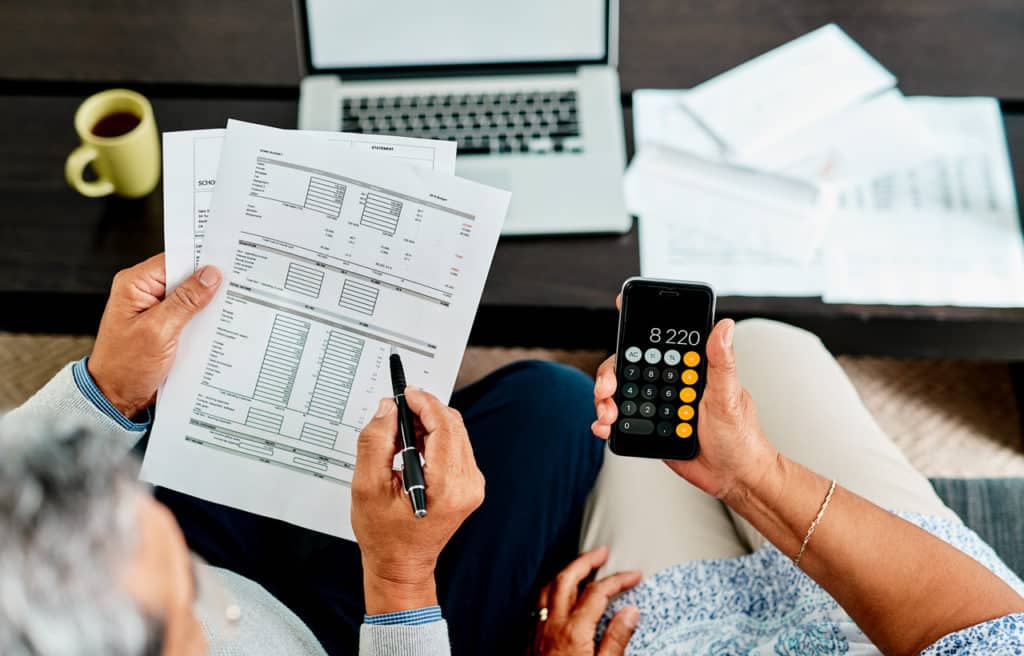 An overhead shot of a couple adding up the total costs of their new manufactured home.