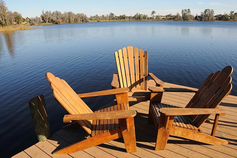 Adirondack chairs on dock overlooking lake.