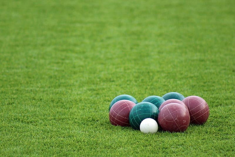 Group of bocce balls on green turf.