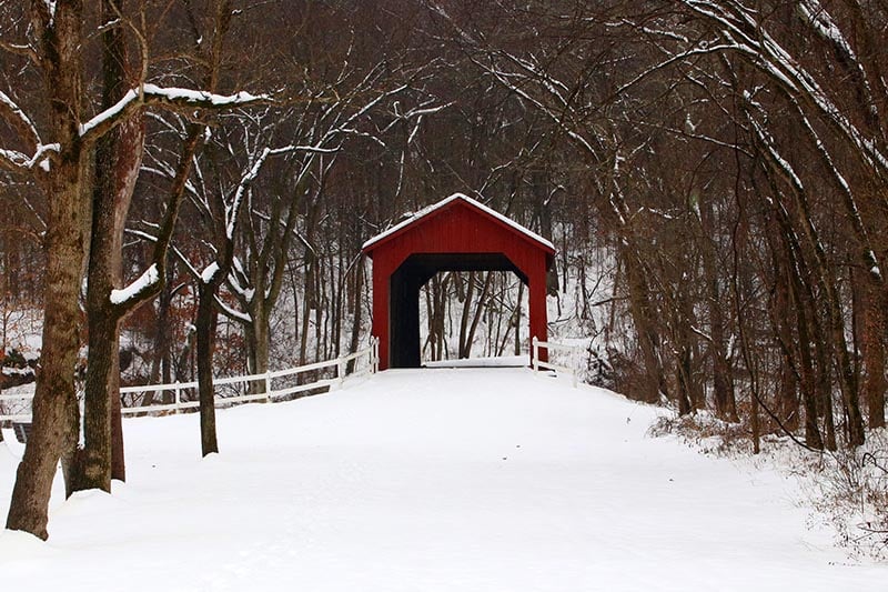 Snowy red covered bridge at Sandy Creek Covered Bridge State Historic Site.