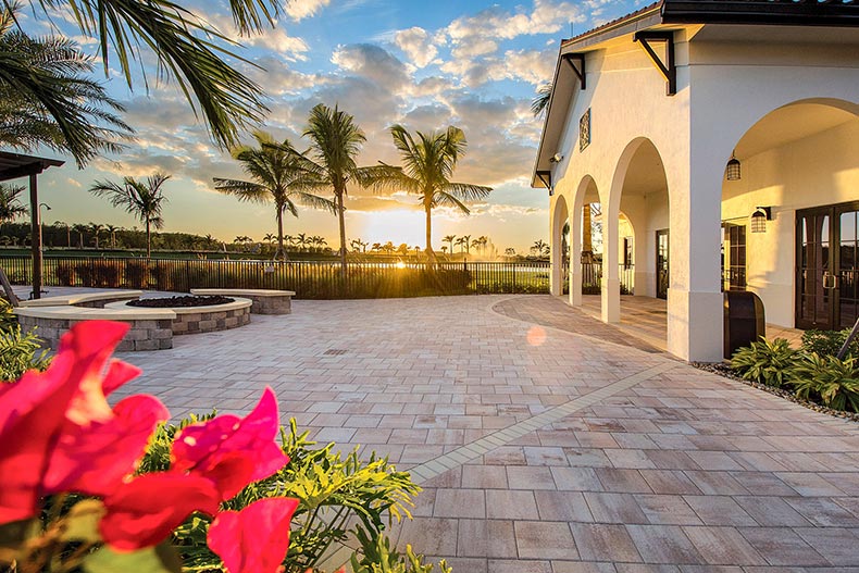 Sunset over palm trees and a community building at Arborwood Preserve in Fort Myers, Florida.