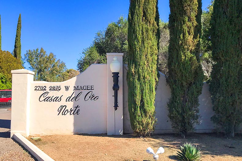 Trees beside the community sign at Casas Del Oro Norte in Tucson, Arizona.