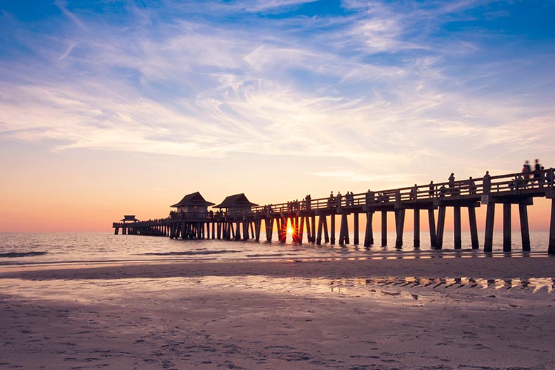 Sunset on the beach at Naples Pier in Naples, Florida.