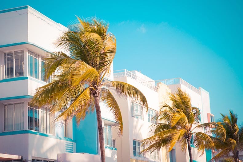 Palm trees and typical retro art deco style buildings seen from South Beach in Miami, Florida.