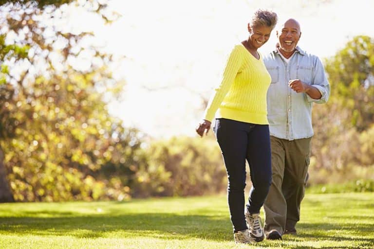 A retired couple walking on the grounds of their 55+ community.