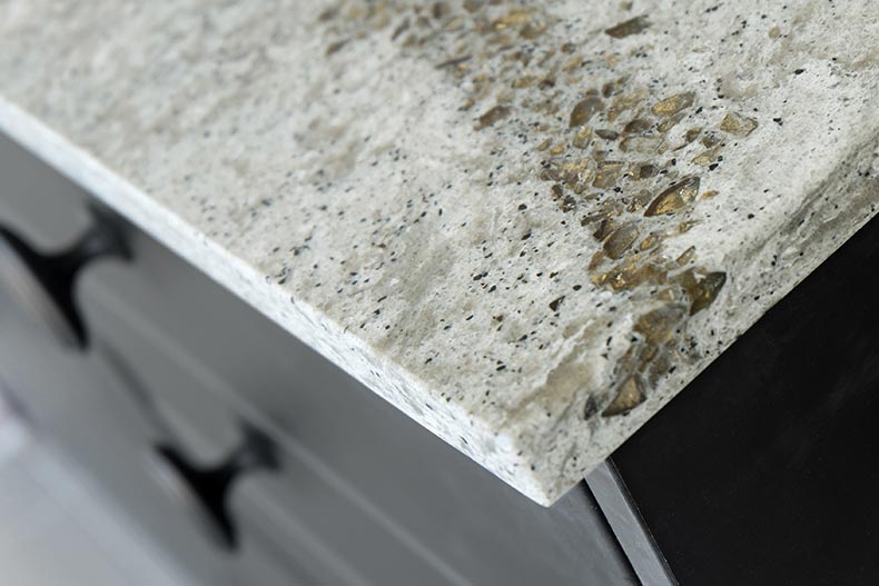 A quartz countertop in a kitchen with a black wooden cabinet.