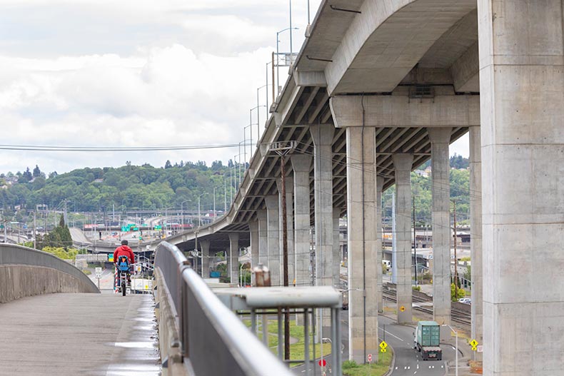 A biker on the Spokane Street Bridge beside the closed West Seattle Bridge in Seattle, Washington.