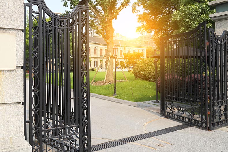 An ornate gate in front of a luxury home.