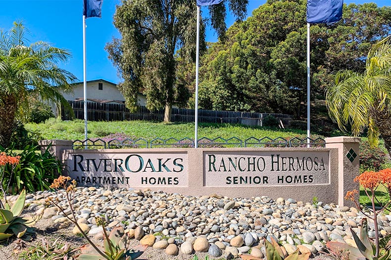 Flags waving above the community sign for Rancho Hermosa in Oceanside, California.