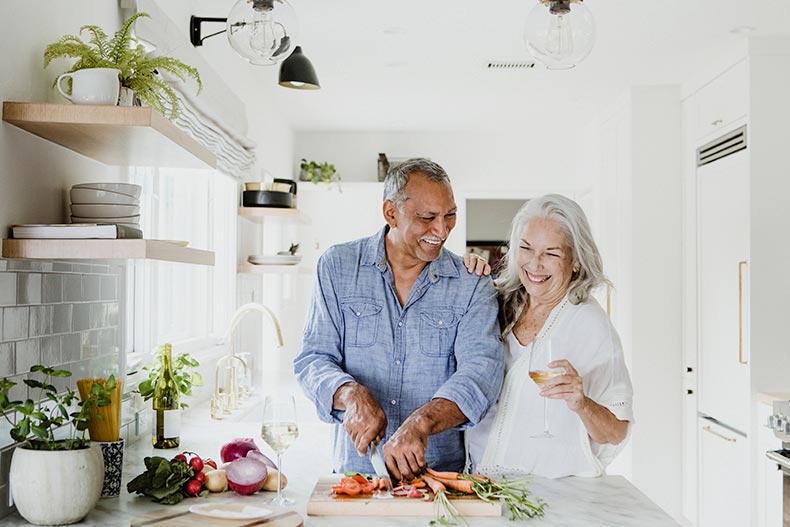 An elderly couple cooking in a kitchen at home in a 55+ community.