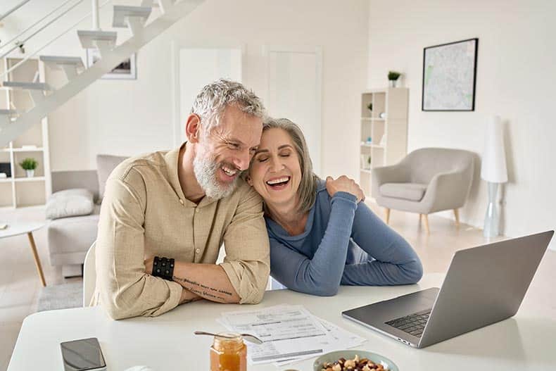 A happy couple researching how they can afford a home in a 55+ community.