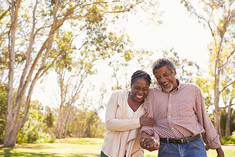 A mature couple enjoying a walk outdoors in their 55+ community.