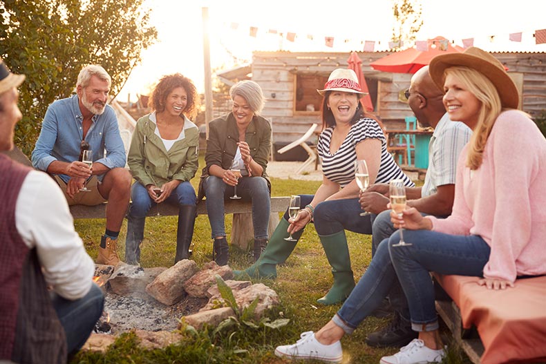 A group of mature friends sitting around a campfire in their 55+ community.