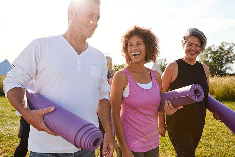 A group of mature friends attending a yoga class in their 55+ community.