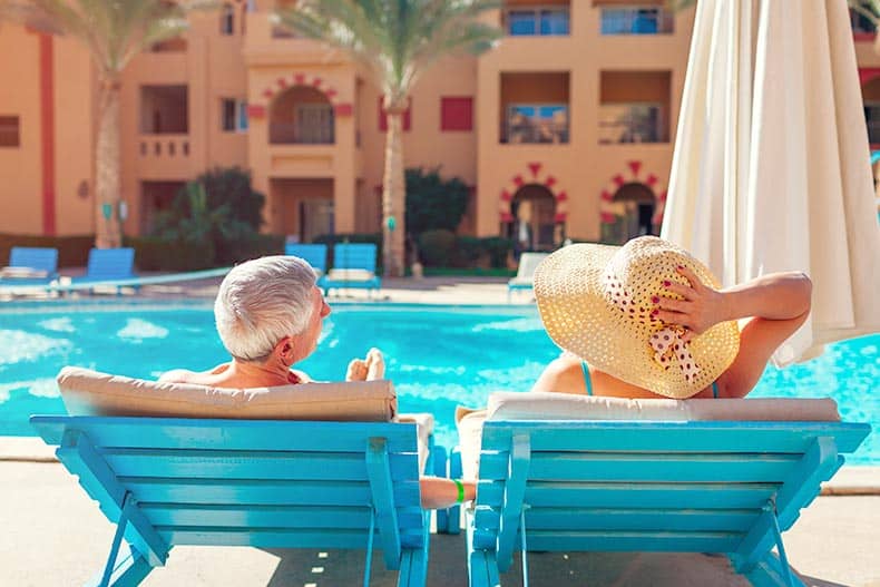 A senior couple relaxing by the swimming pool in their 55+ community.