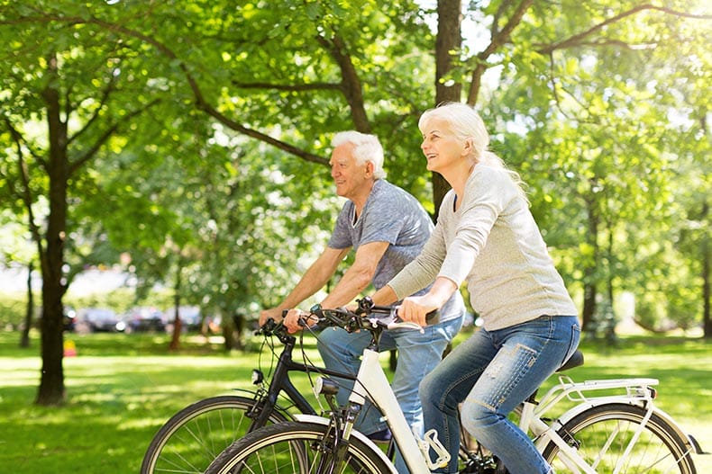 A senior couple riding bikes in their 55+ community.