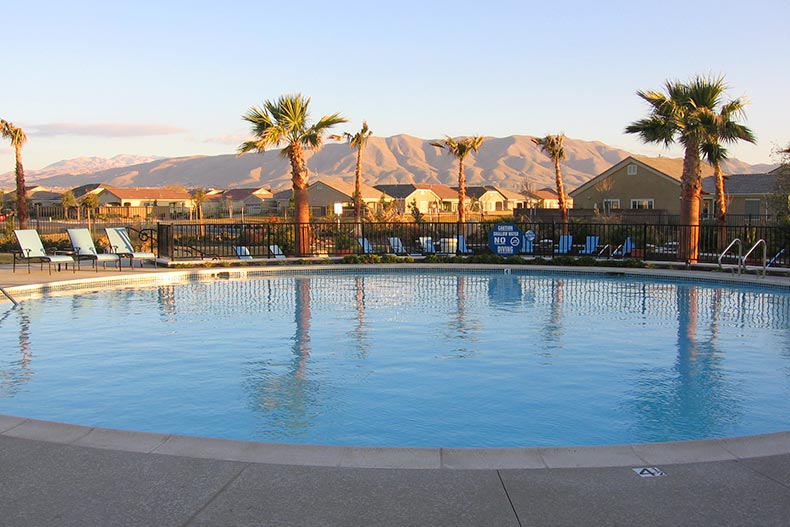 Mountains and palm trees surrounding the outdoor pool at Sun City Apple Valley in Apple Valley, California.