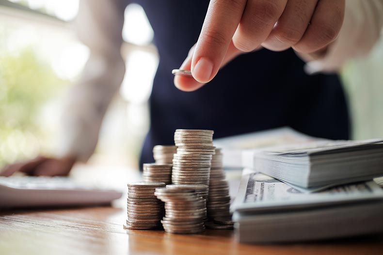 A banker stacking coins and counting money for a home sale.