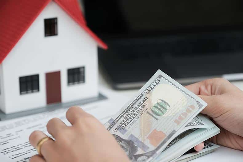 Counting dollar bills from the sale of a home.