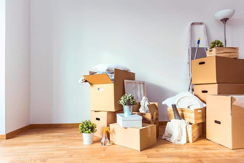 A stack of cardboard boxes with items being sold because homeowners are downsizing.