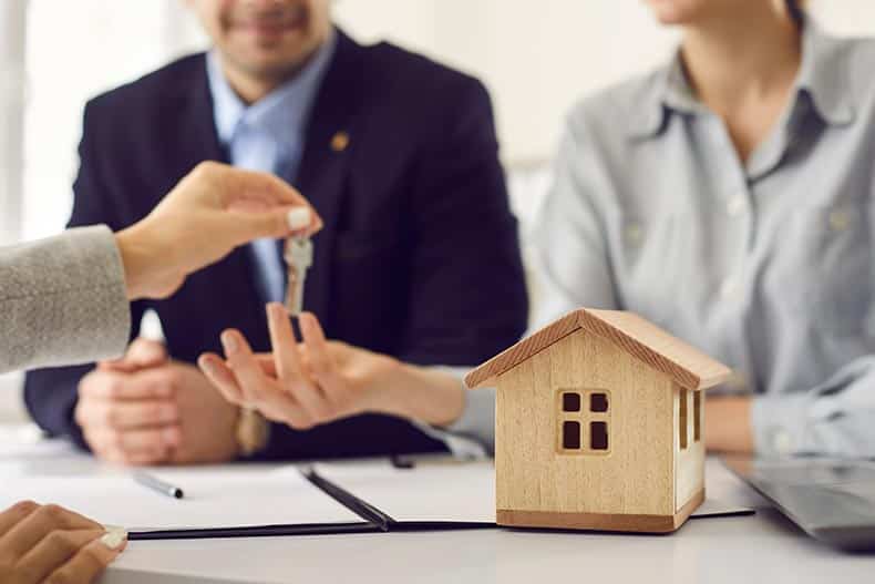 A real estate agent giving the keys to new homeowners.
