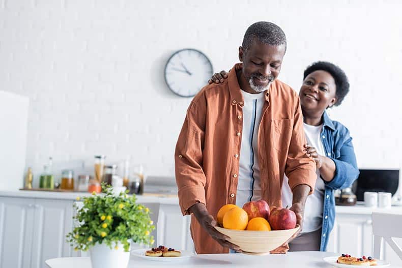 A happy couple in the kitchen in their home.