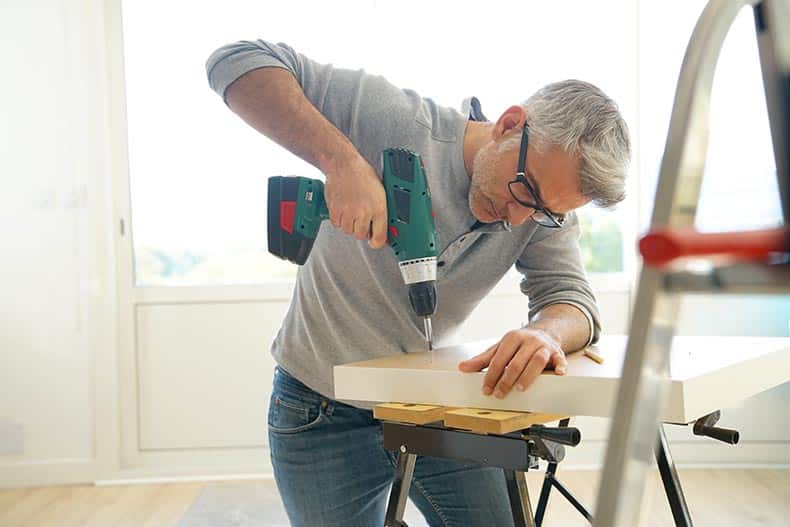 A 55+ man working on a DIY project at home.