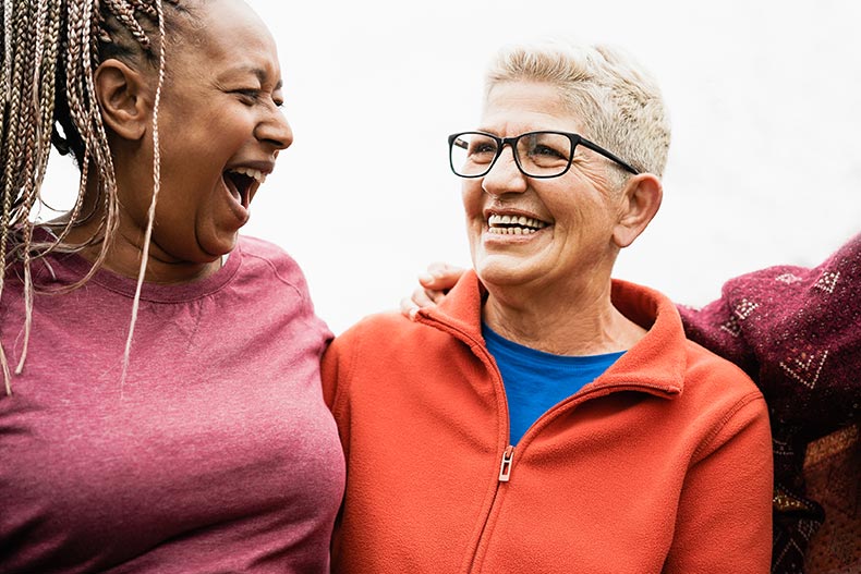 Mature female friends smiling and having fun in their 55+ community.