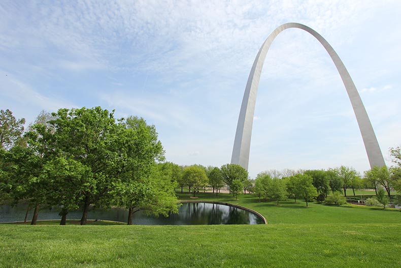 Green trees and grass surrounding the St. Louis gateway arch in Missouri.