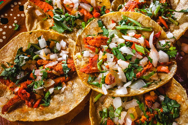 Closeup of Mexican street tacos with corn tortillas, onions, and cilantro.