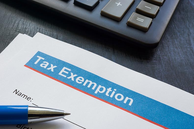 Closeup on a Tax Exemption form beside a keyboard and a pen.