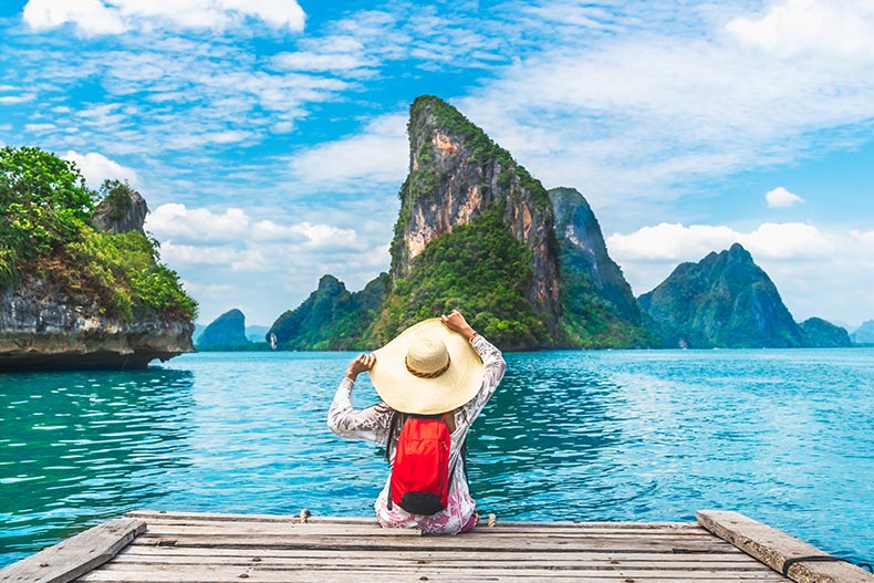 A woman relaxing on a wood bridge on Phang-Nga Bay in Thailand.