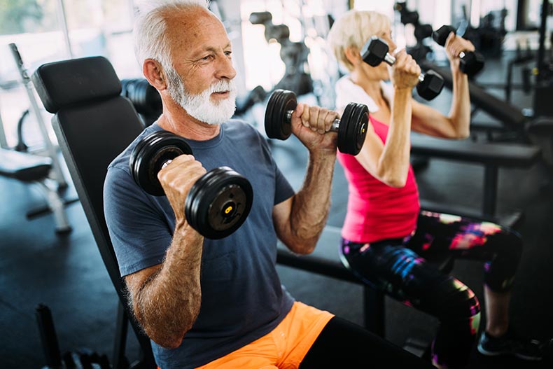 A senior man and woman doing exercises in a fitness center to stay healthy.